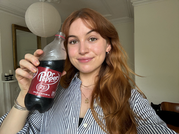 a woman holding a bottle of soda