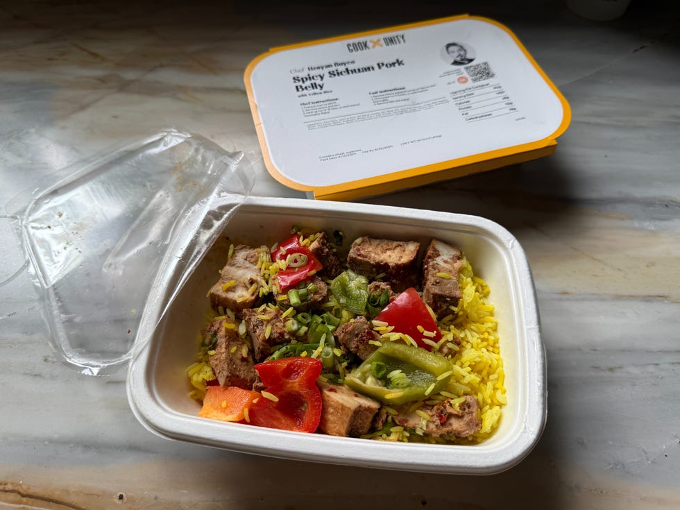 container of spicy sichuan pork belly with rice and vegetables