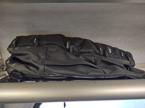 matador backpack stored away on an overhead section on a bus