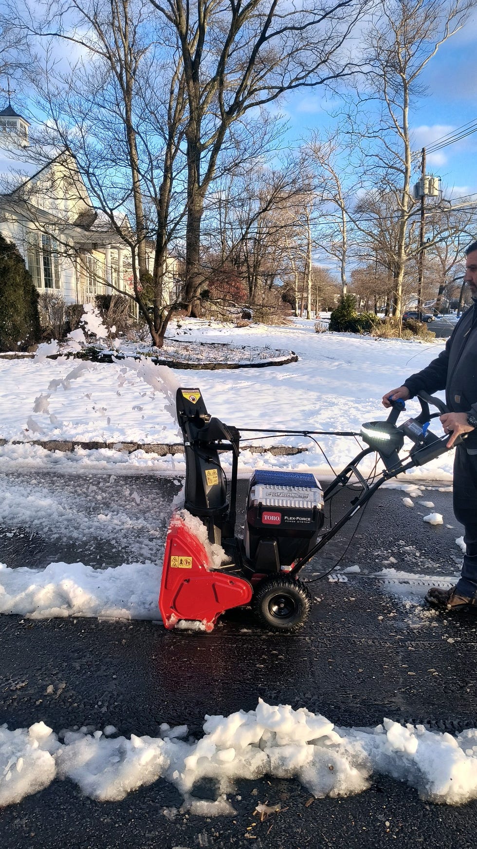 a tester uses a snow blower to clear snow from a driveway