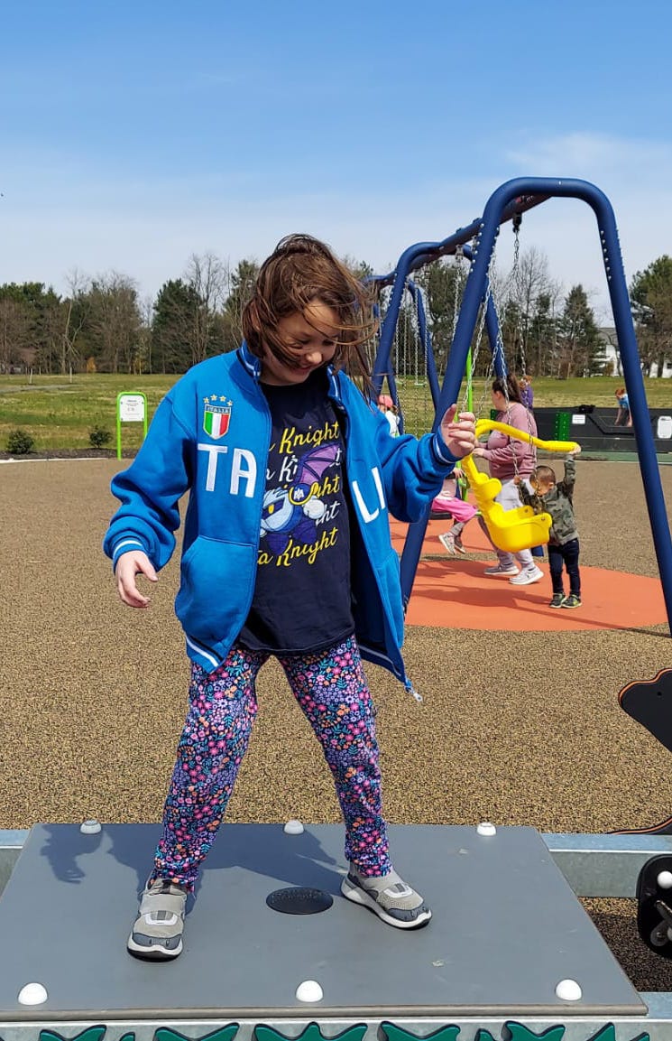 a girl in flowered leggings wears gray target all in motion sneakers, a good housekeeping pick for best children's walking shoe