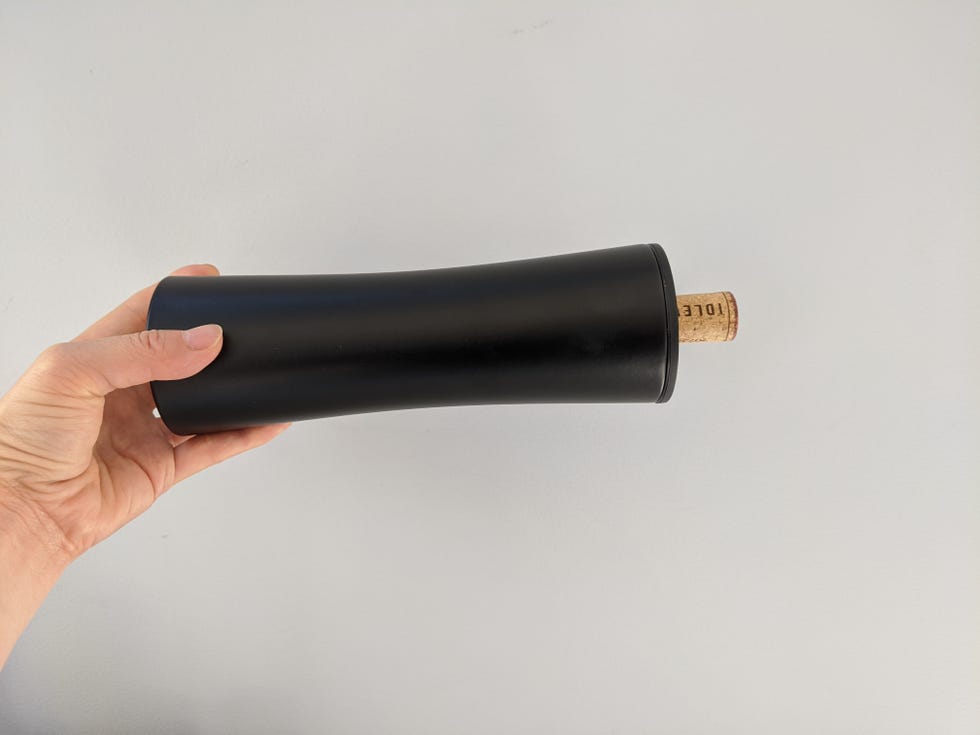 best electric wine openers a hand is holding a black electric wine opener horizontally which ejects the cork from the screw