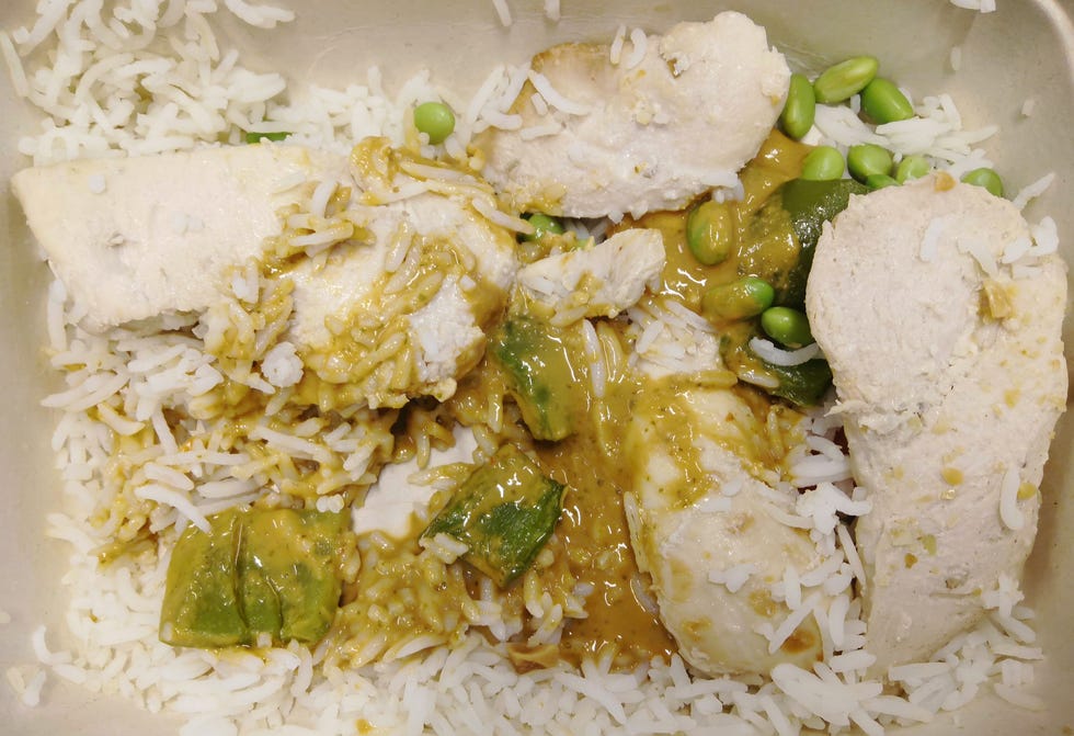 calo chicken satay rice bowl container of rice topped with chicken and green vegetables in sauce