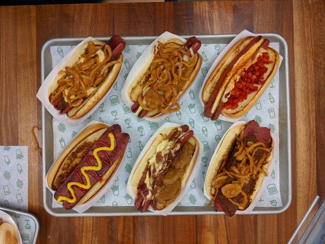 array of assorted hot dogs with toppings served on a tray