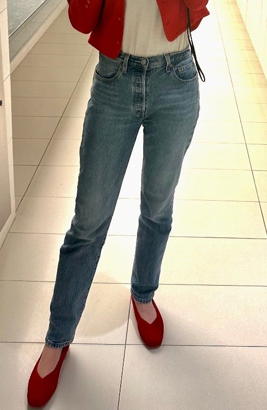 a person from the waist down modeling jeans from levis in a bathroom