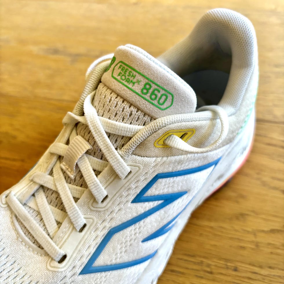 a closeup of a white running shoe with colorful branding