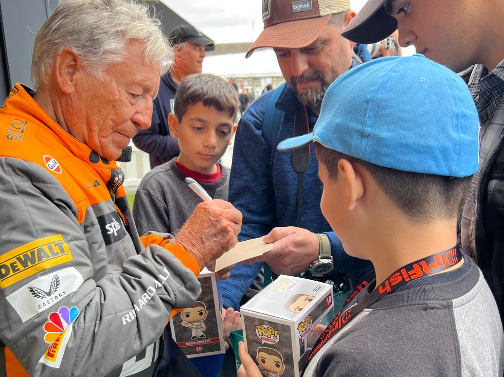 a man handing a boy a piece of paper