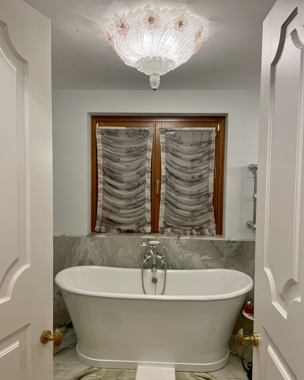a bathtub with a chandelier above it