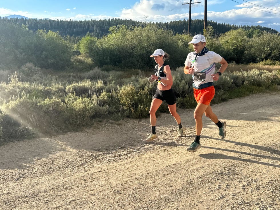 two runners run side by side on dirt road