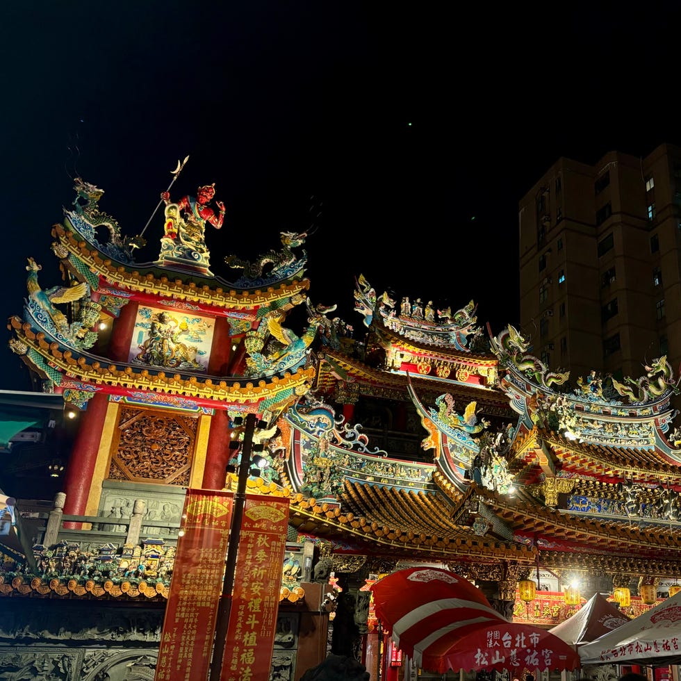 a vibrant temple facade illuminated at night showcasing intricate details and decorations