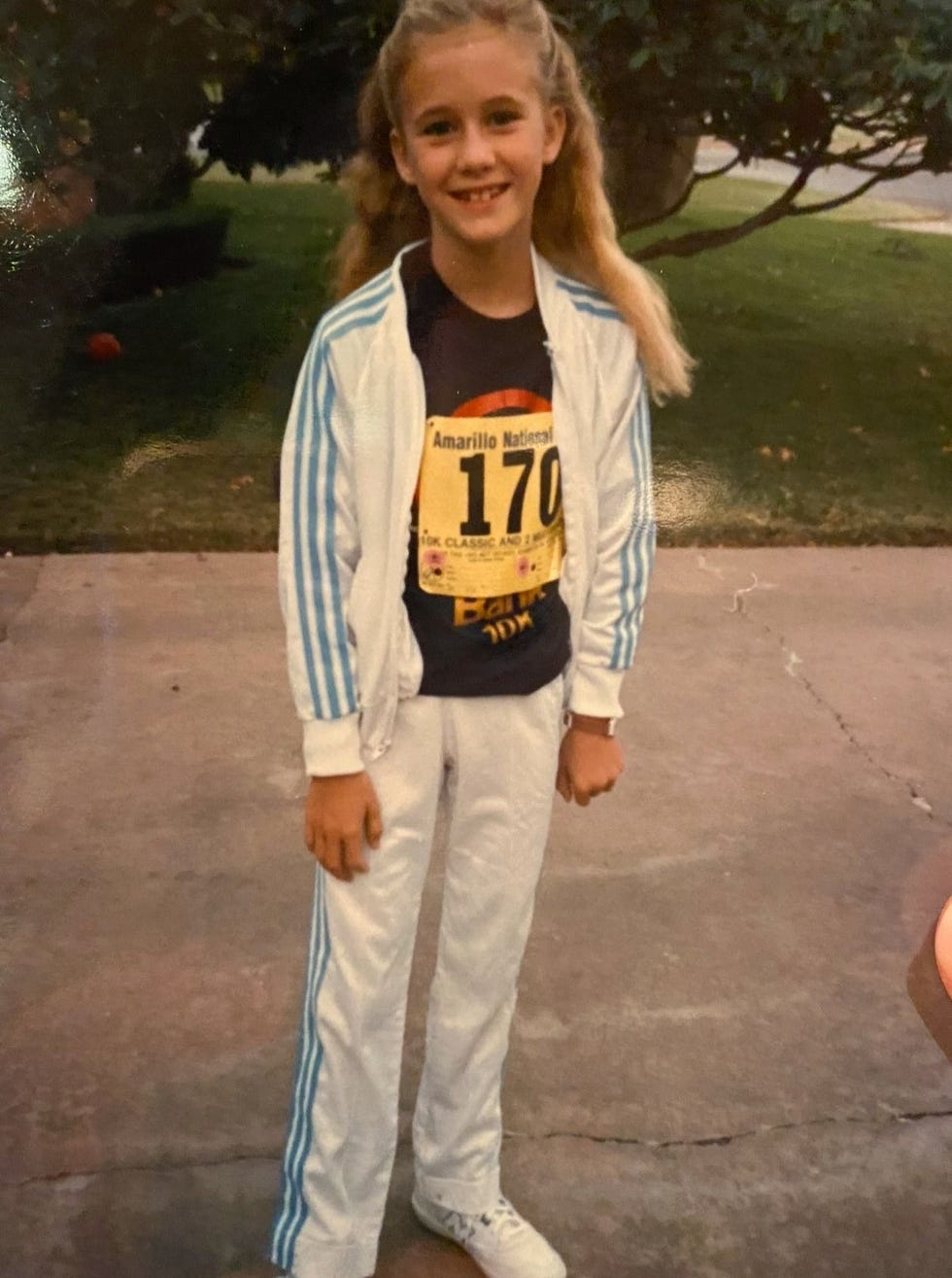 child dressed in athletic attire with a race bib