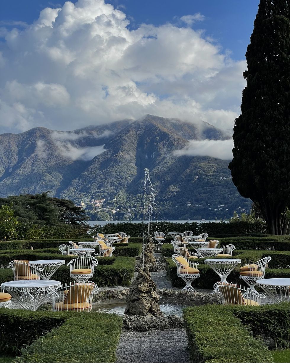 a fountain in a pond with mountains in the background