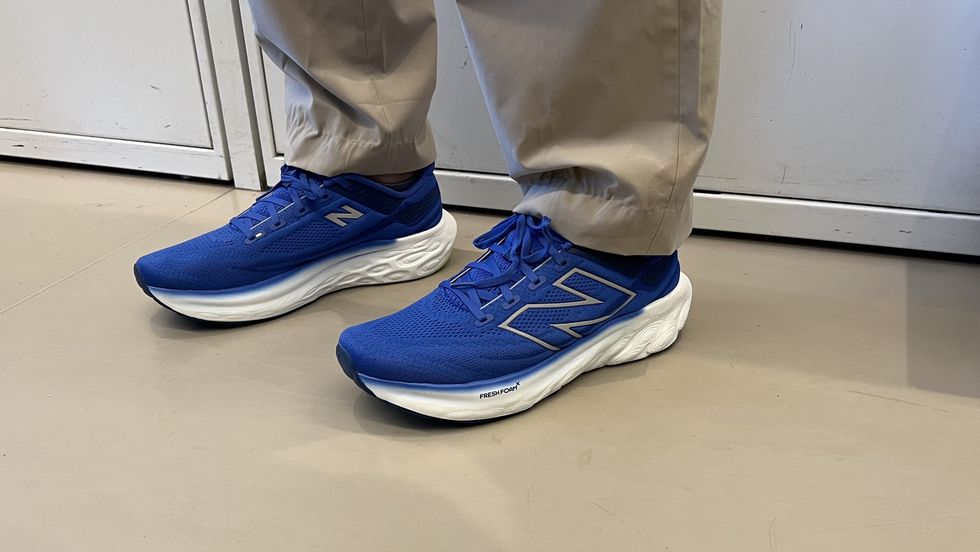 a person wearing bright blue new balance fresh foam 1080v13 sneakers as part of good housekeeping's testing for the best walking shoes for men