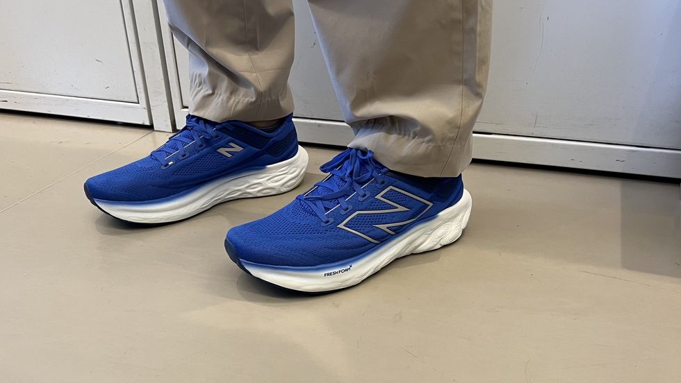a person wearing bright blue new balance fresh foam 1080v13 sneakers as part of good housekeeping's testing for the best walking shoes for men