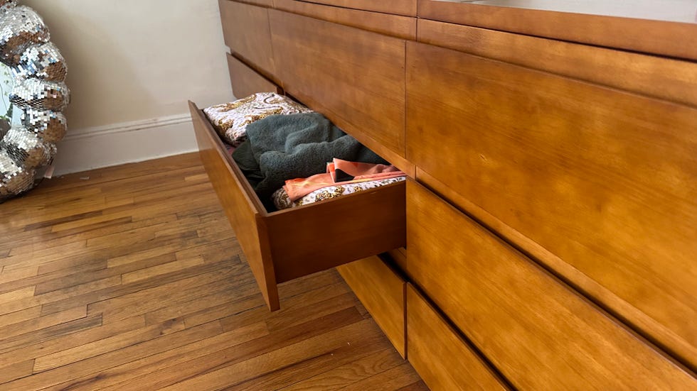 an open drawer on the thuma dresser filled with linens