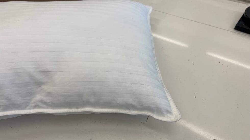 a close up of the white striped beckham hotel bed pillow as part of good housekeeping's testing for the best pillows for side sleepers