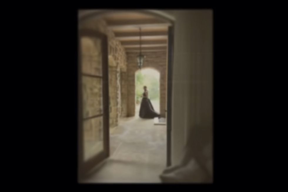 a screenshot of a person walking through a hallway