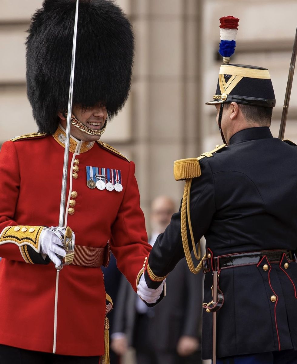 a person in a garment next to a person in a uniform