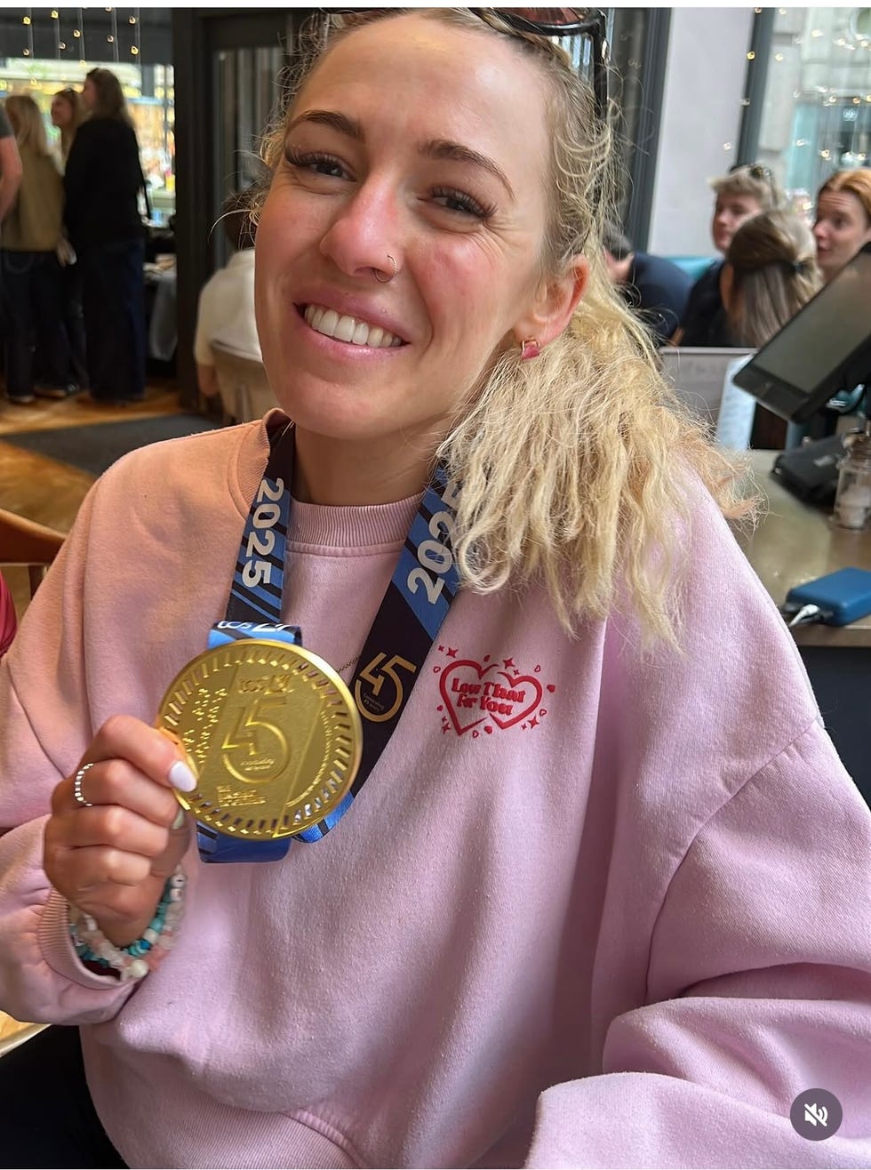 a young person holding a gold medal with a blue ribbon