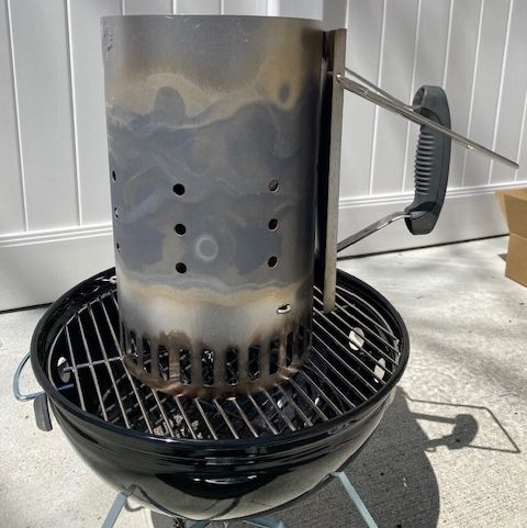a portable charcoal grill with a chimney on it