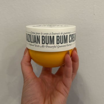 a hand holding a tub of brazilian bum bum cream a hand holding a tub of brazilian bum bum cream