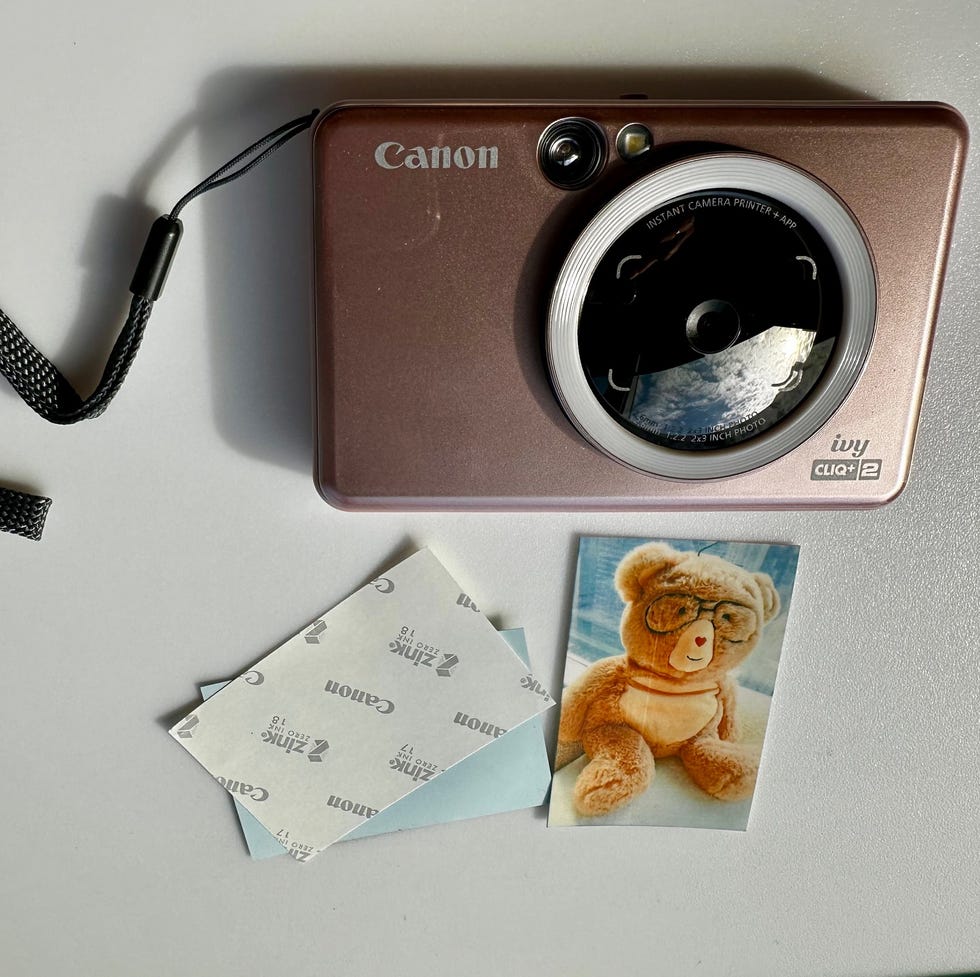 Canon Ivy camera with its sticky back instant prints a pink canon ivy instant print camera with two prints that have sticky back and can work like stickers, including one of a photo taken of a teddy bear, part of a good housekeeping review of the best cameras for kids