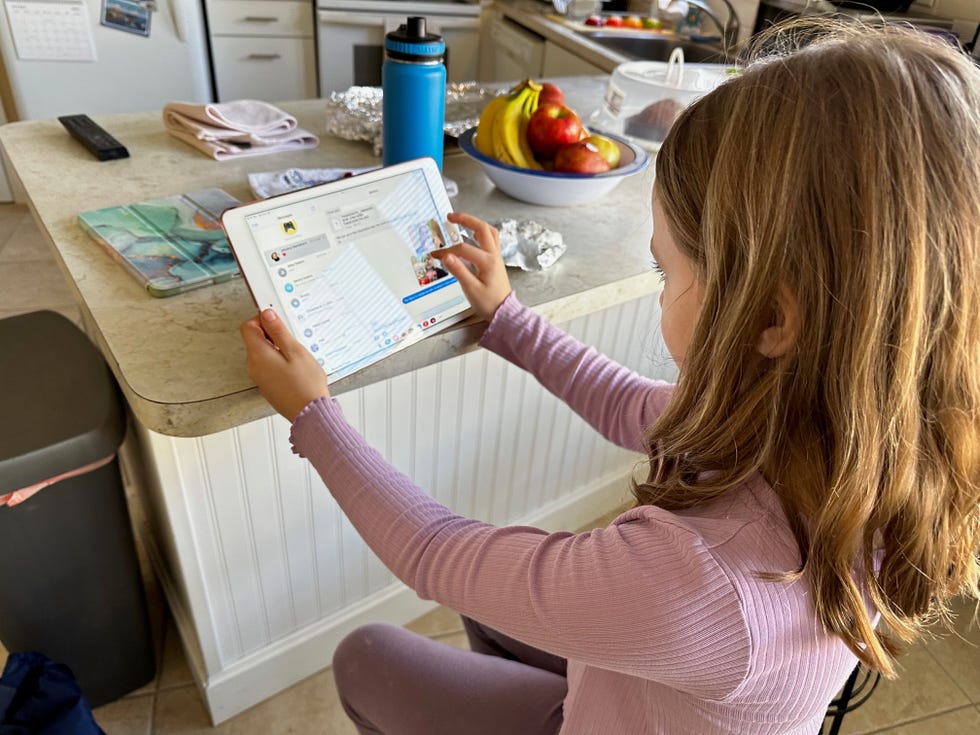 child using a tablet in a kitchen setting, part of a good housekeeping story on the best kids tablets