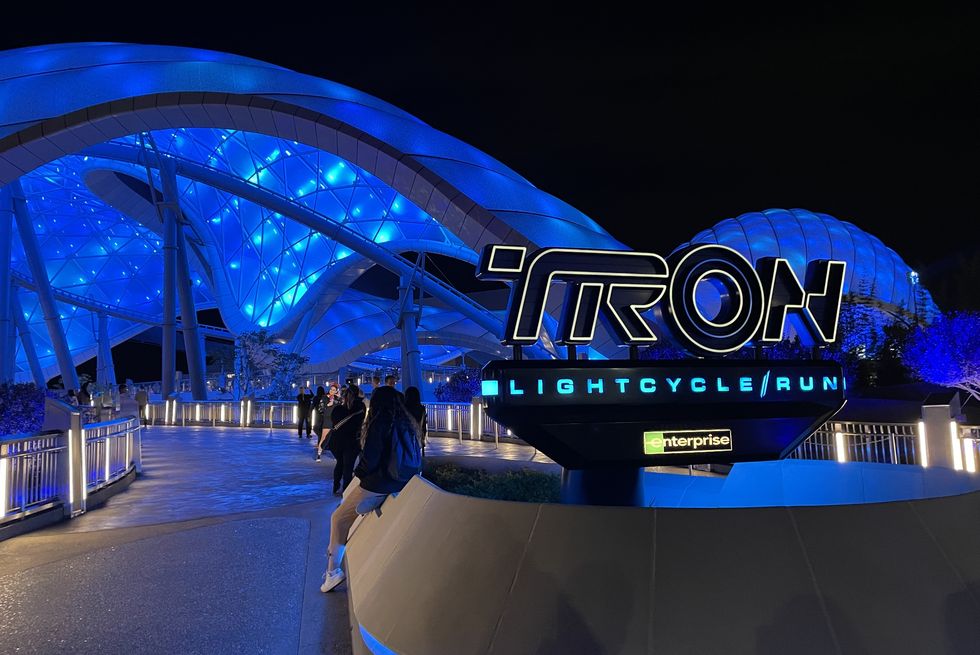 tron lightcycle run at disney world sign and ride lit up at night