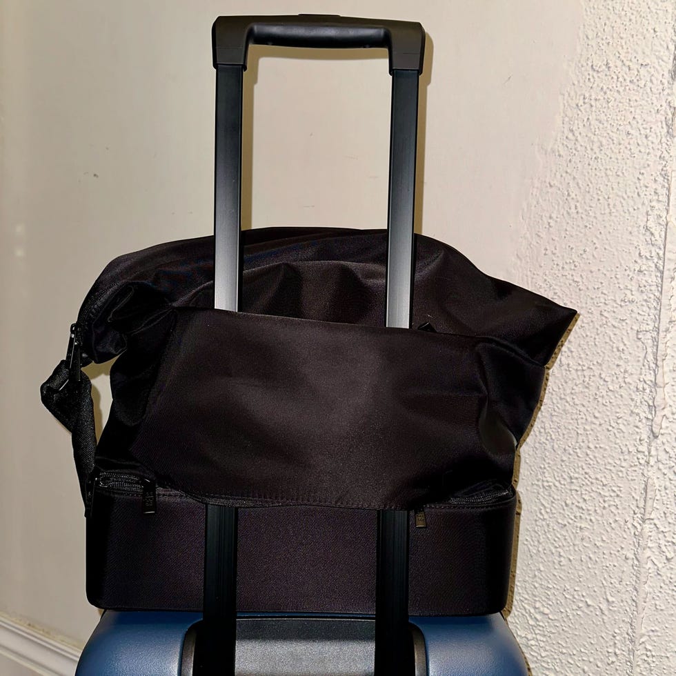 the day tripper from béis sitting on top of a navy suitcase
