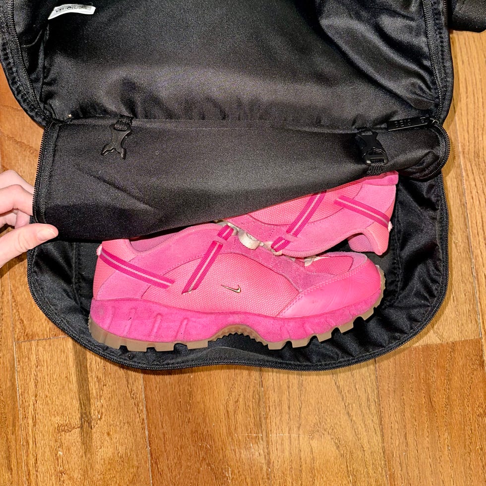 a pair of pink shoes inside a black bag
