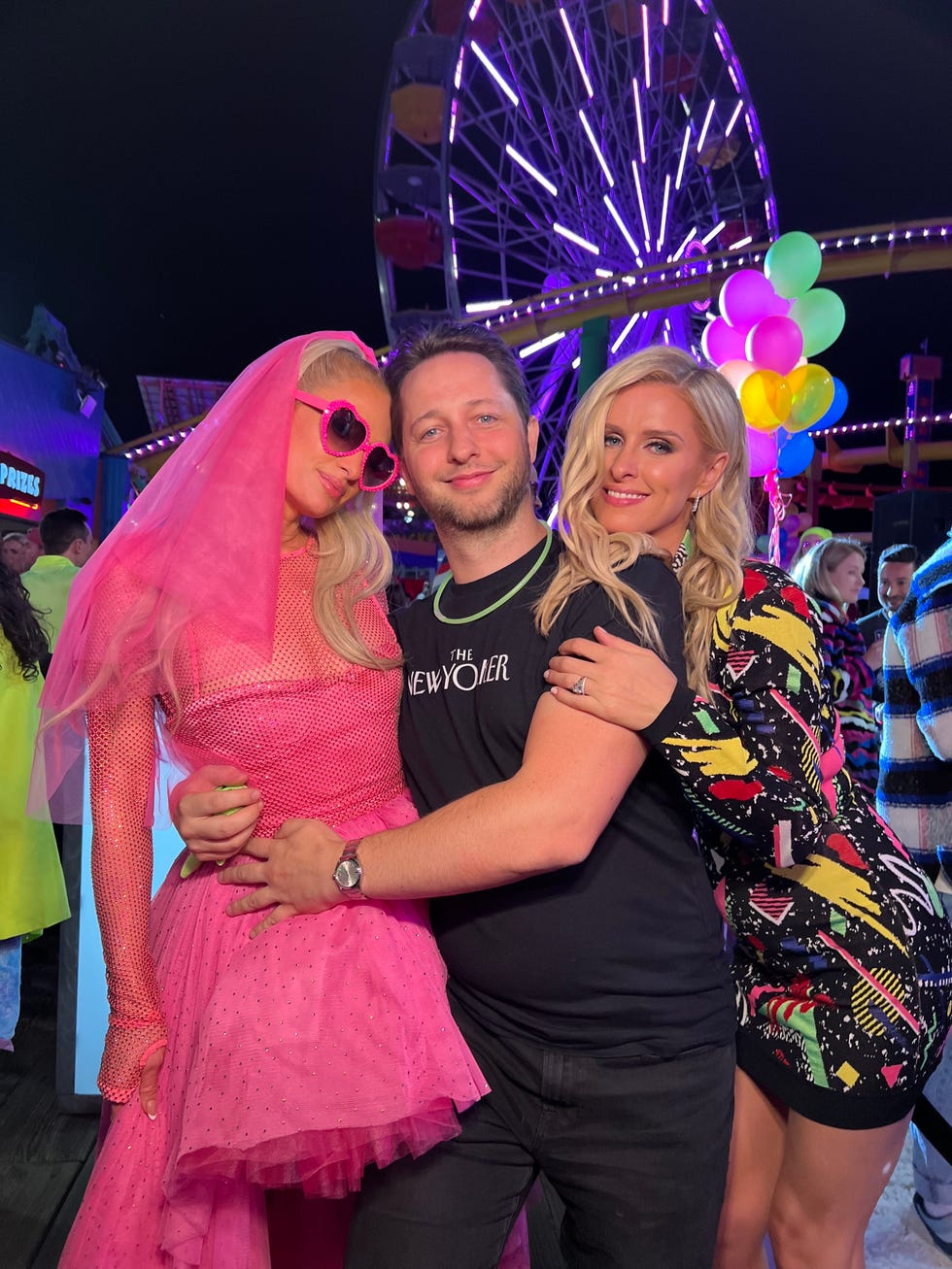 a vibrant gathering at a fairground with three individuals posing together