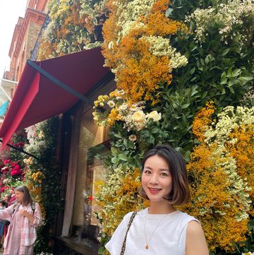 a person posing in front of a garden of flowers