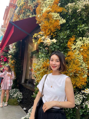 a person posing in front of a garden of flowers