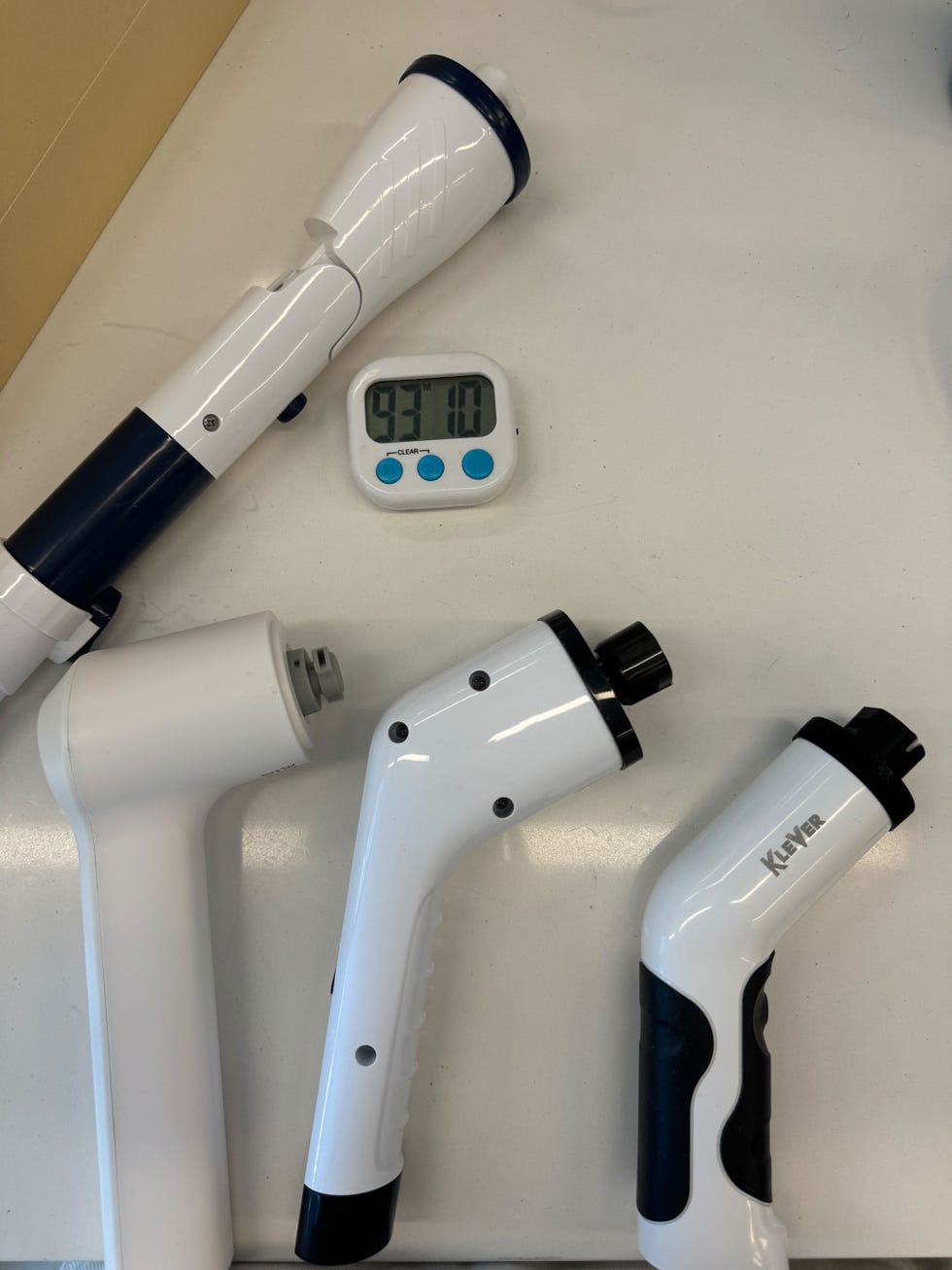 four electric spin scrubbers laying on a counter with a timer showing 93 minutes