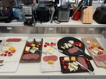 several charcuterie boards shown with meat, cheeses and strawberries