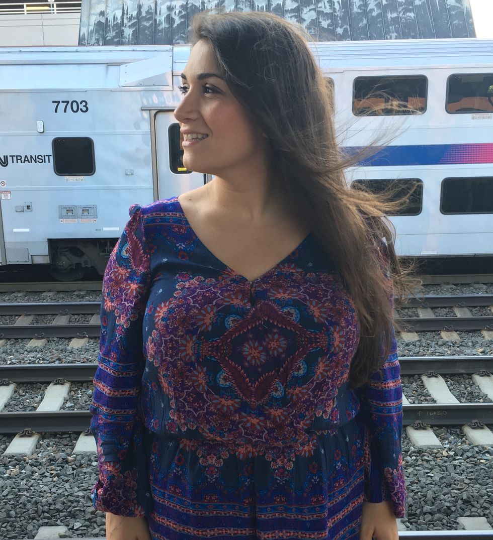 the author standing in front of a train with her long hair blowing behind her