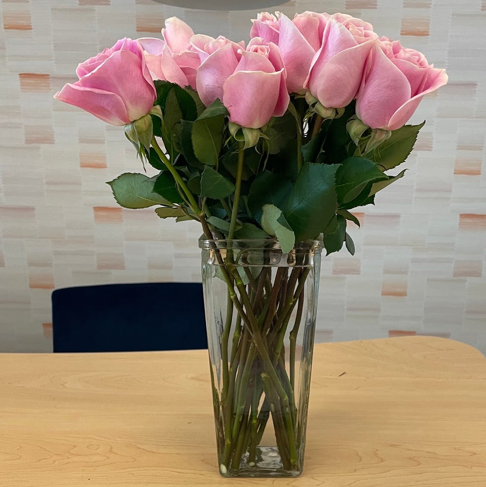 a glass vase filled with roses