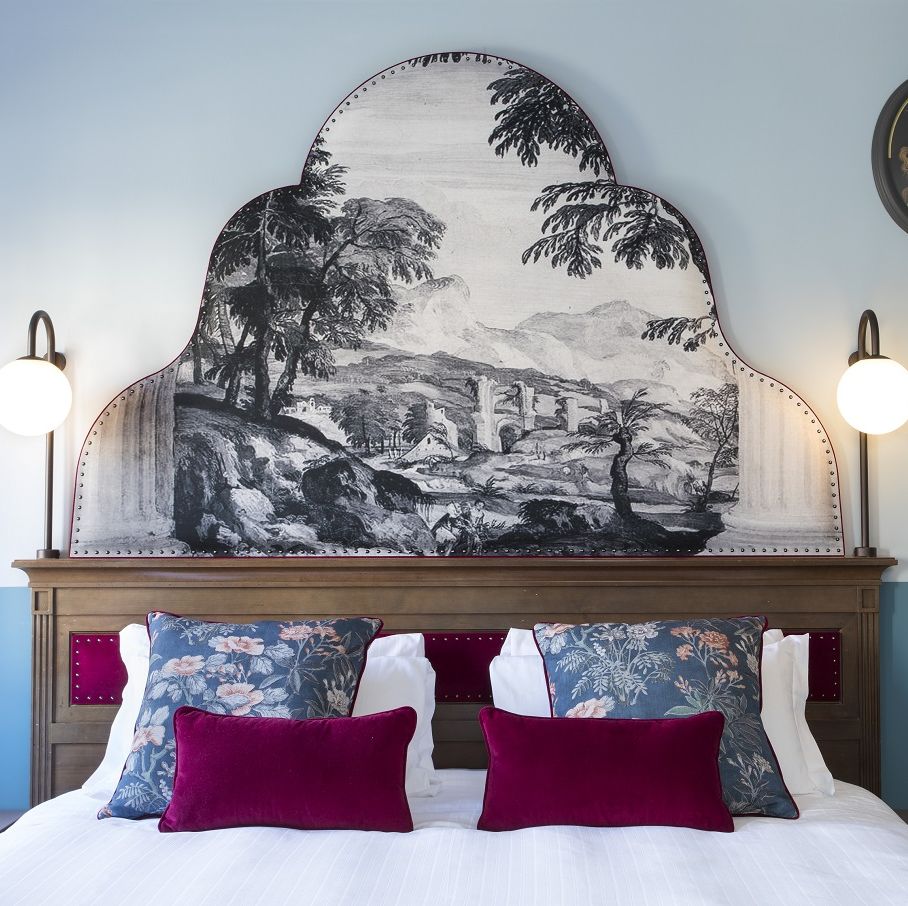 a bed with pillows and a painting on the wall