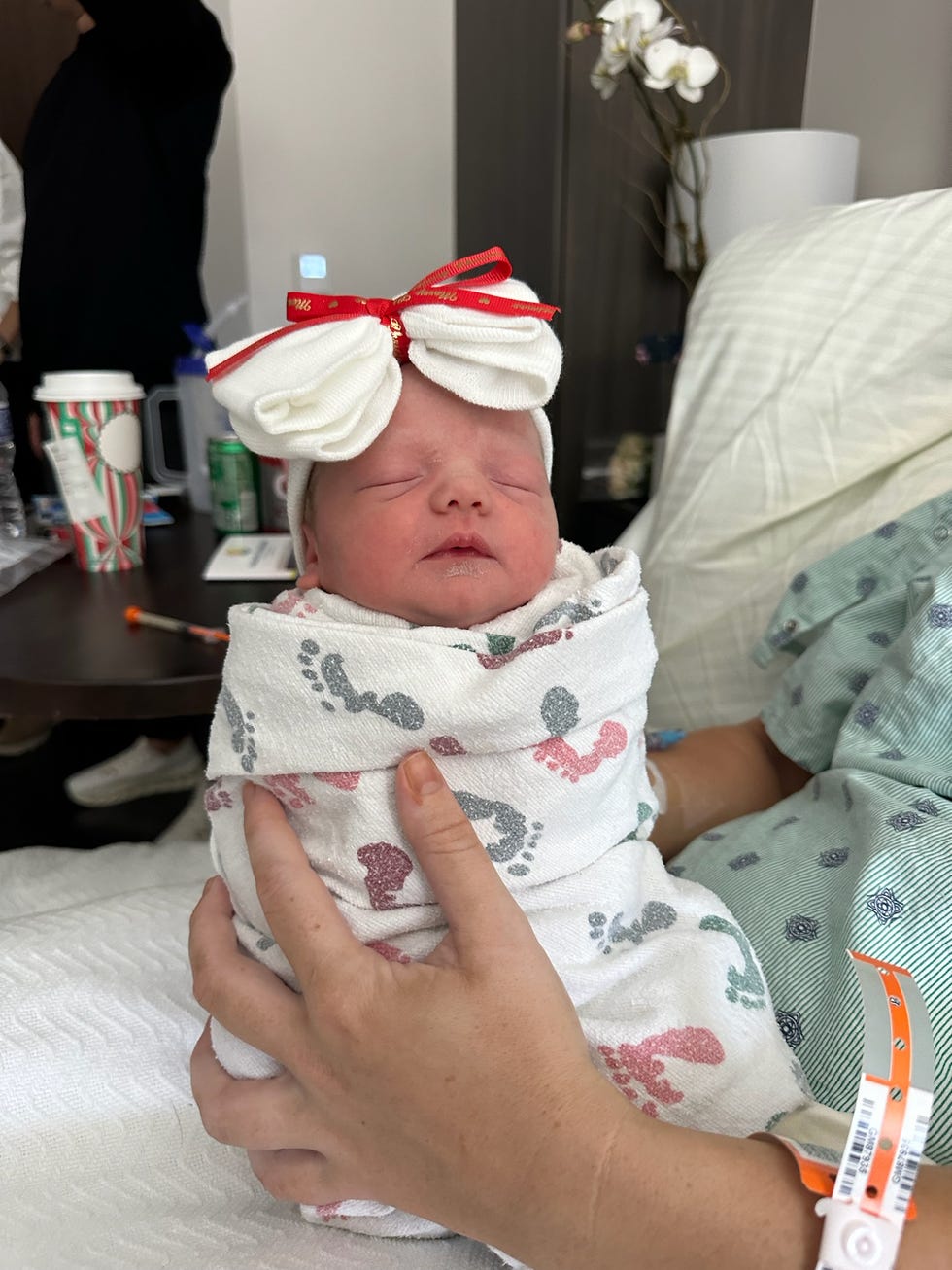 newborn baby wrapped in a blanket with a decorative bow