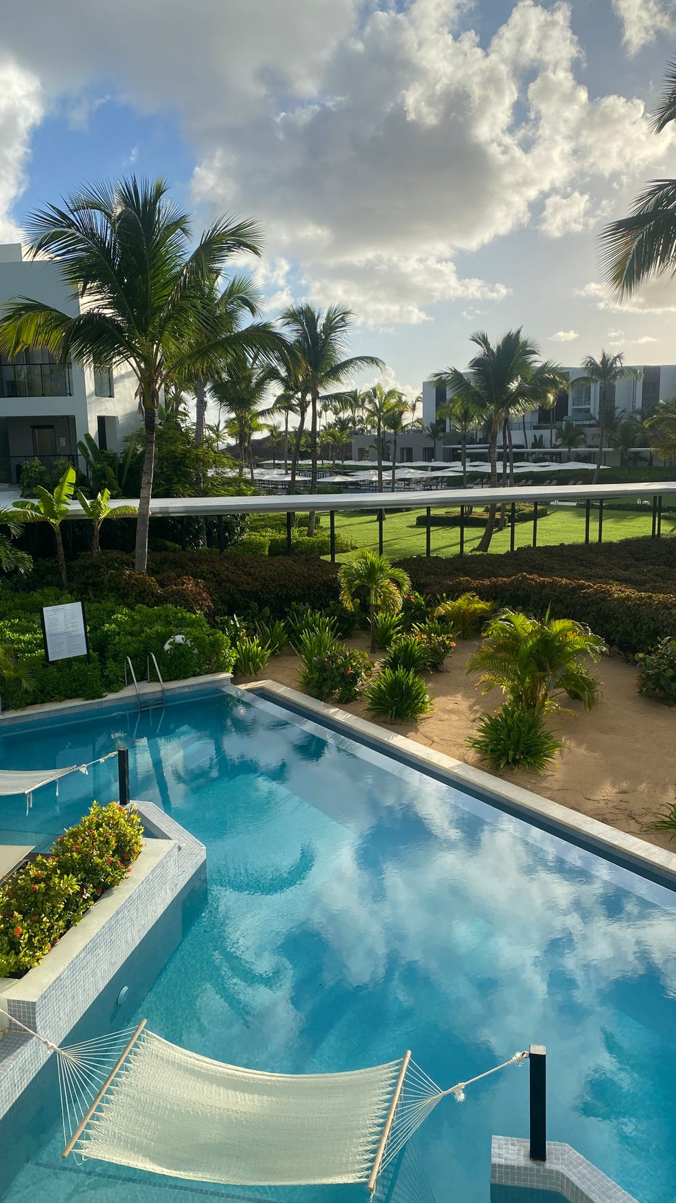 a pool with trees and buildings in the background