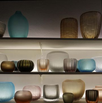 a shelf with many vases and glasses on it