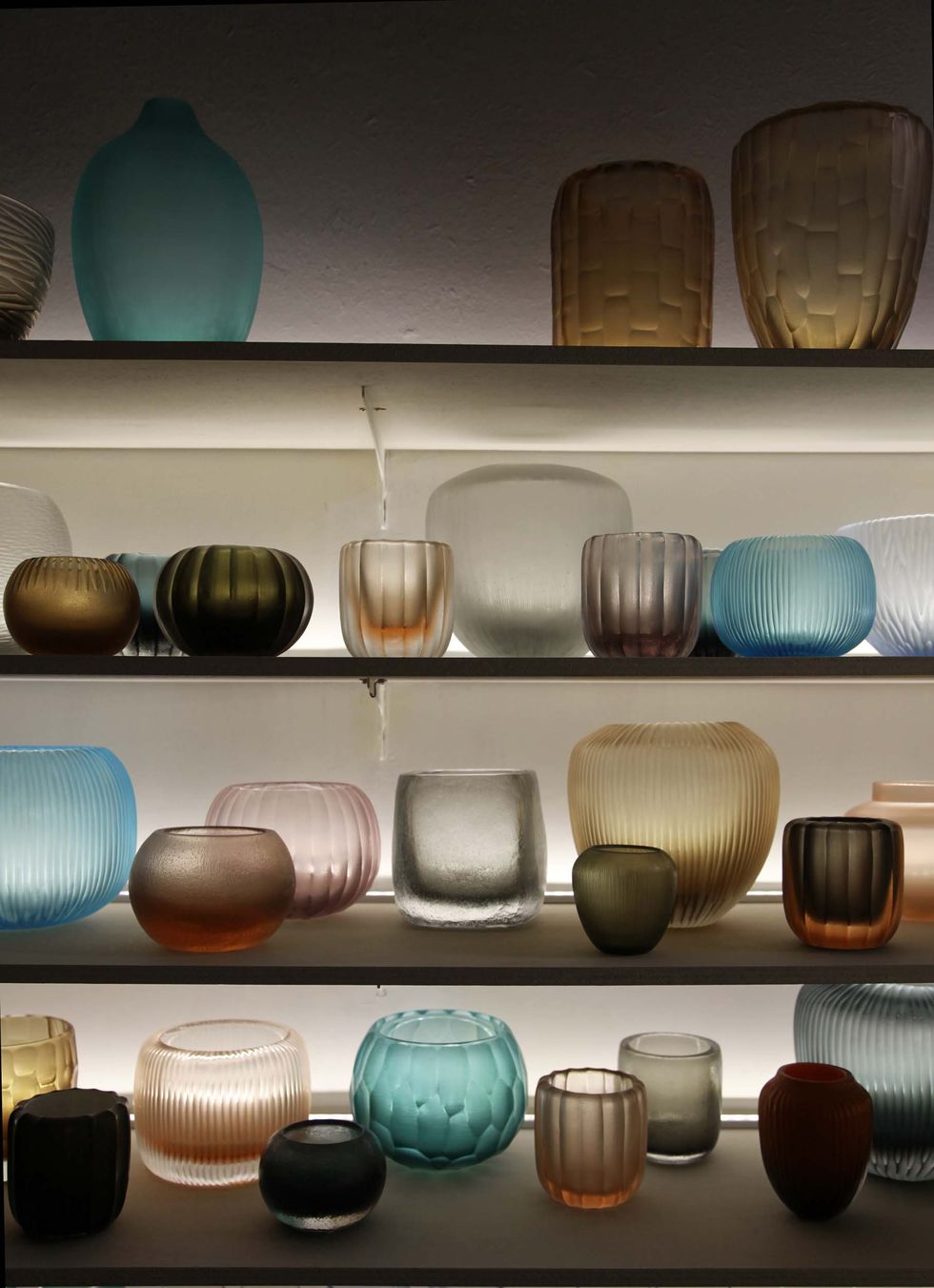 a shelf with many vases and glasses on it