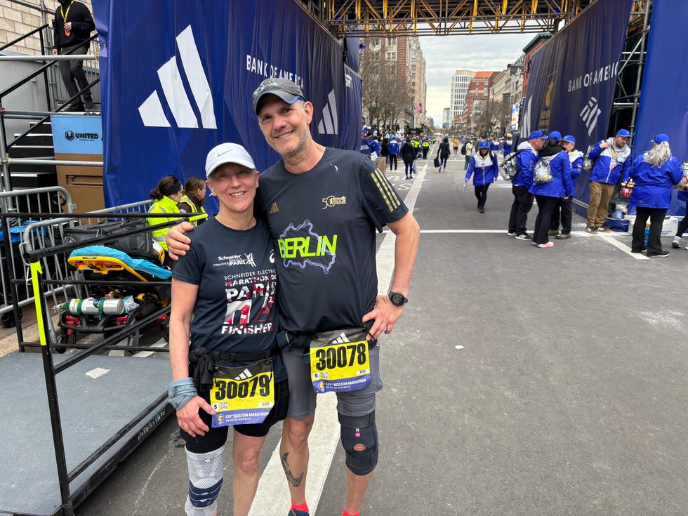 two runners pose at marathon finish line