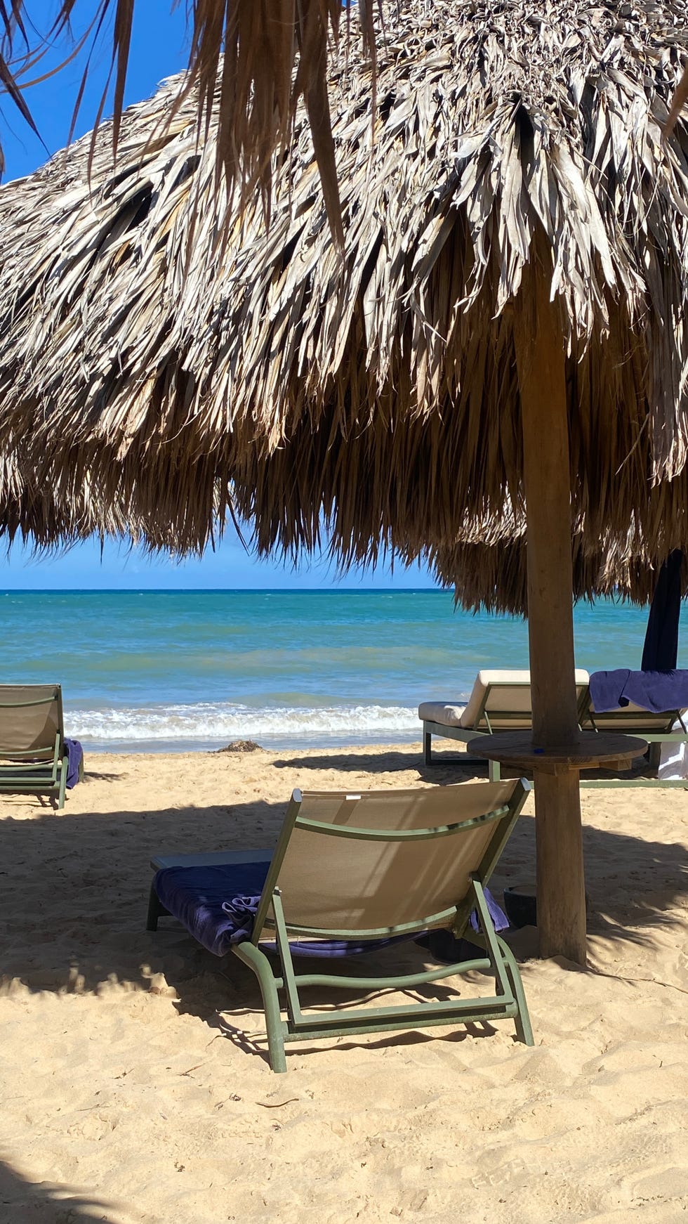 a beach with chairs and parasol