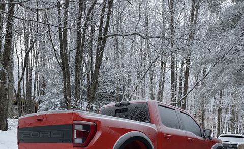 orange ford raptor in the snow