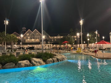 a view of the disney beach club resort and pool at night