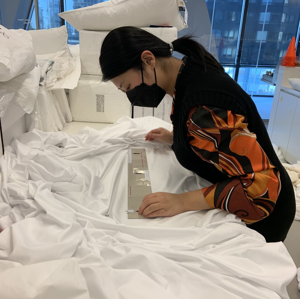 a good housekeeping institute textiles analyst measuring shrinkage on bed sheets after wash testing in an evaluation to find the best sheets