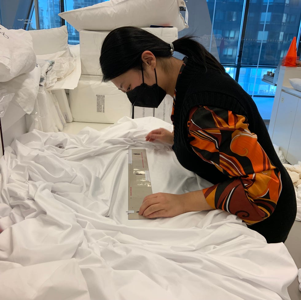 a good housekeeping institute textiles analyst measuring shrinkage on bed sheets after wash testing in an evaluation to find the best sheets