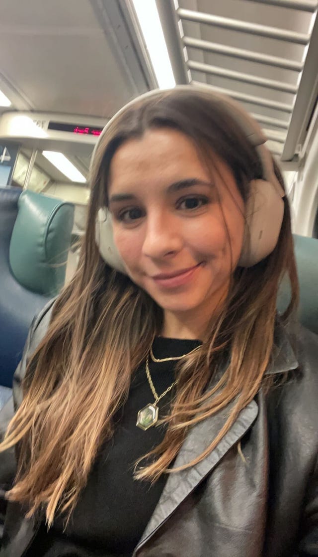 isabella wearing sony xm5 noise canceling headphones on the train
