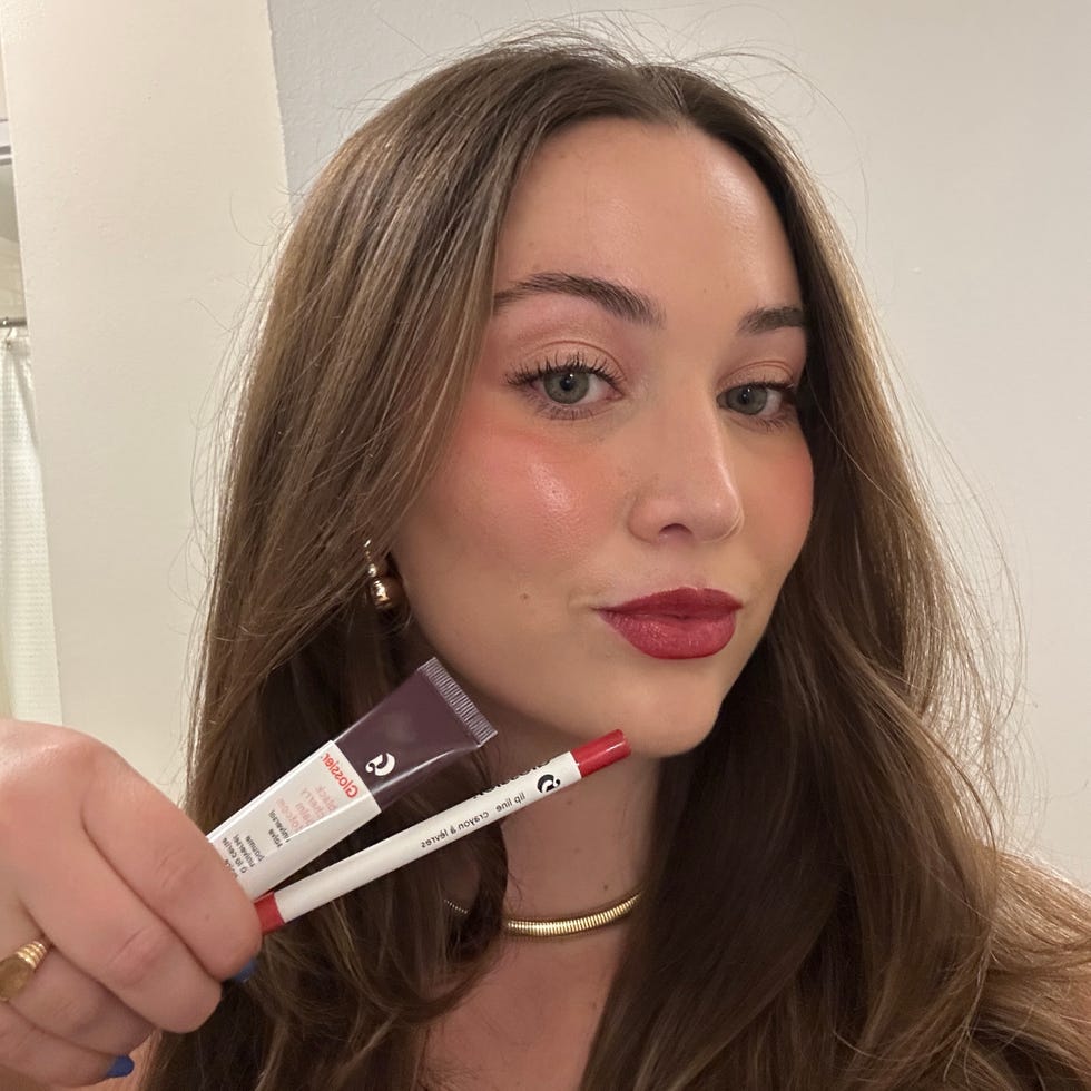 a person holding two cosmetic products one a lip color and the other likely a lip liner